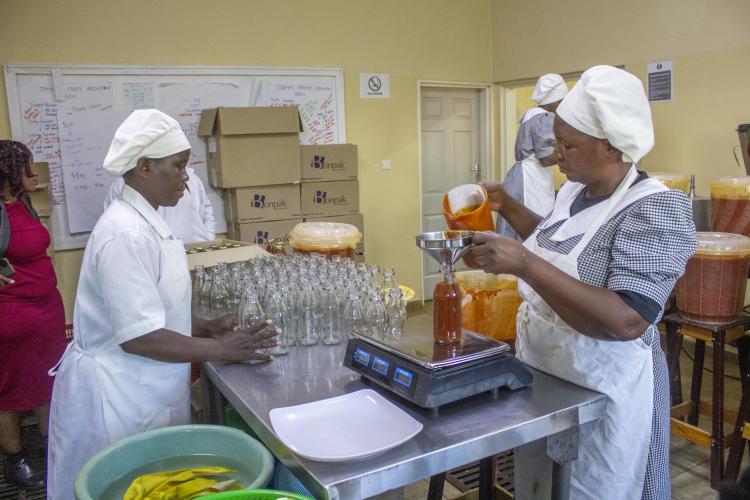 Kwithu staff packaging tomato that has been processed